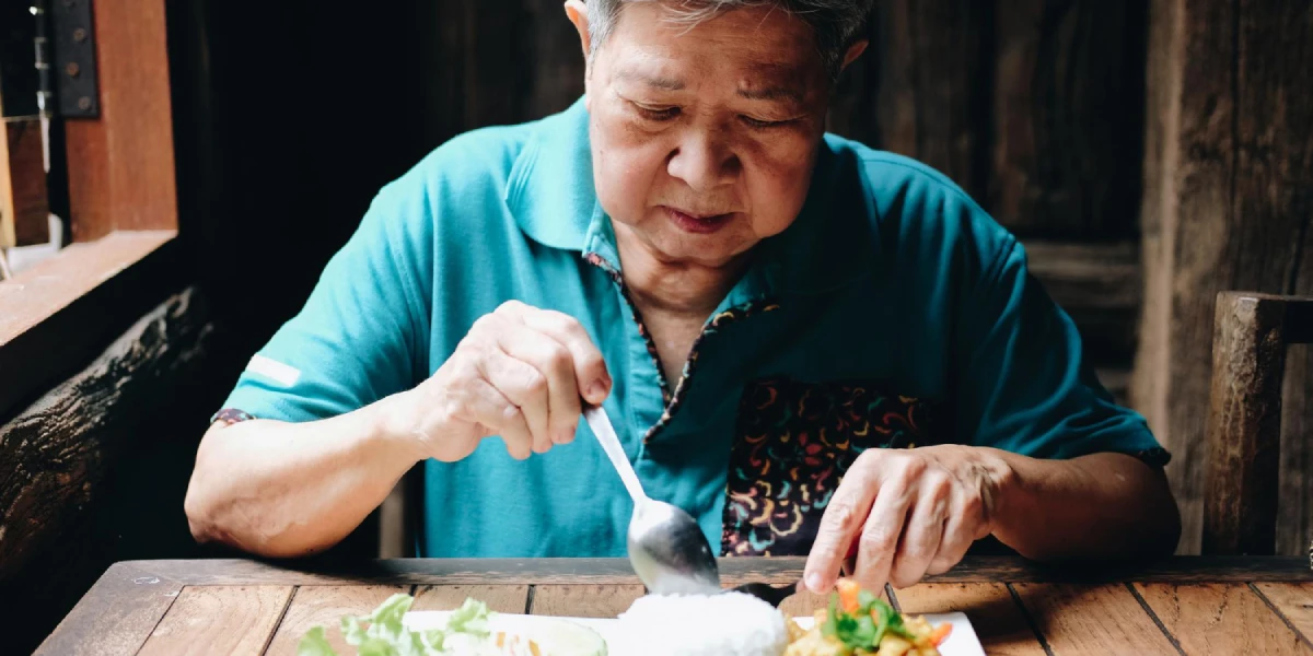 Starsza azjatka spożywa posiłek